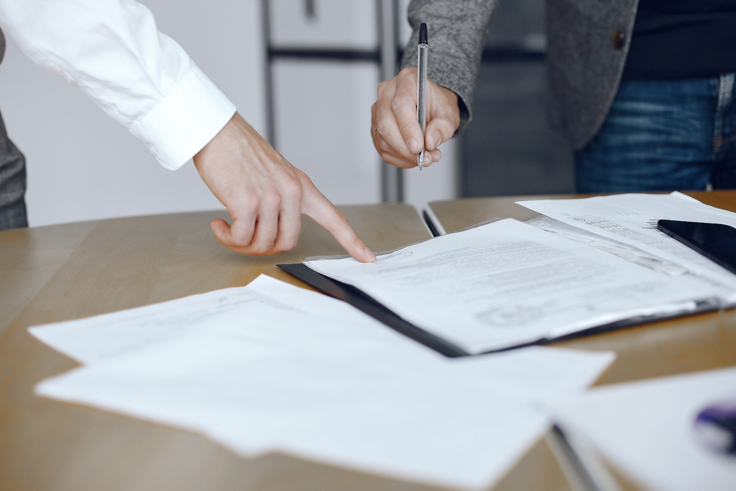 Dues persones revisant i signant un contracte